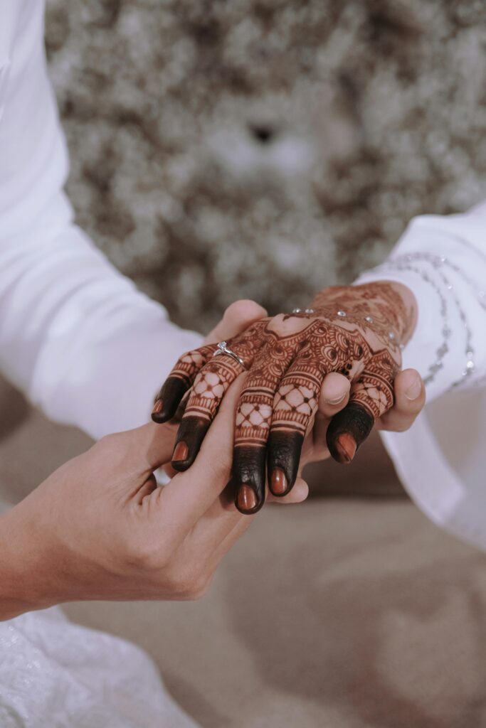 Intricate henna design on hands during a traditional wedding, symbolizing love and unity.